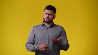 Sarı arka planda bir şey yapmayı planlayan bir adamın 4K videosu. Duyguların kavramı.