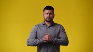 Sarı arka plan için kavga etmek isteyen kızgın bir adamın 4K videosu. Duyguların kavramı.