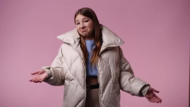 Wideo Dziewczyny Która Wątpi Macha Rękami Różowym Tle Pojęcie Emocji — Wideo stockowe