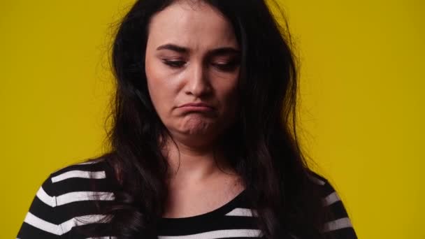 黄色い背景の上に悲しそうにポーズしている1人の女の4K動画 感情の概念 — ストック動画