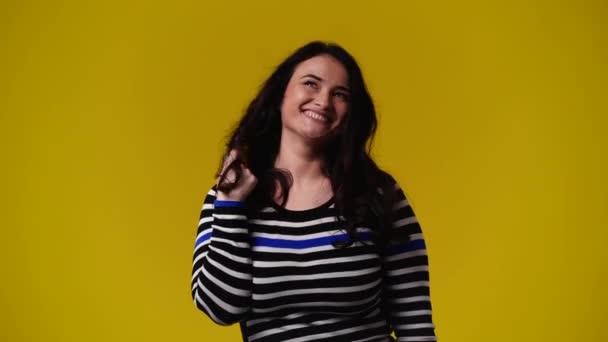 4K视频 一个女人卷着头发 在黄色背景下思考着什么 情绪的概念 — 图库视频影像