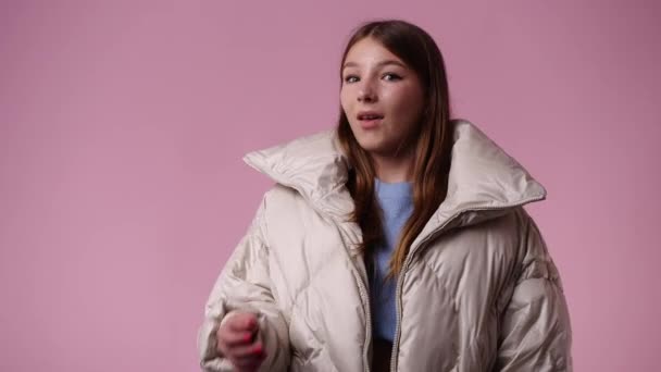 ピンクの背景にびっくりする1人の女の子の4Kスローモーションビデオ 感情の概念 — ストック動画