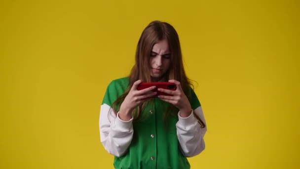 Video Una Chica Usando Teléfono Sobre Fondo Amarillo Concepto Emociones — Vídeos de Stock