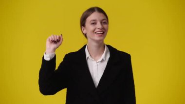Bir kızın sarı arka plana vurduğu 4K video. Duygu kavramı..