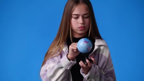 一个女孩在蓝色背景下与地球合影的4K视频 情感的概念 — 图库视频影像