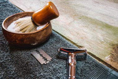 Parlak güvenlik jileti, tıraş fırçası ve kabın içinde köpük. Kırsal ahşap masada eski usul ıslak tıraş, fotokopi alanı ile.