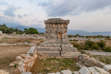 Xanthos Antik Şehir. Mezar taşı ve antik şehir Xanthos 'un kalıntıları - Türkiye' nin Kas, Antalya kentindeki Letoon, günbatımında. Lycia 'nın başkenti.