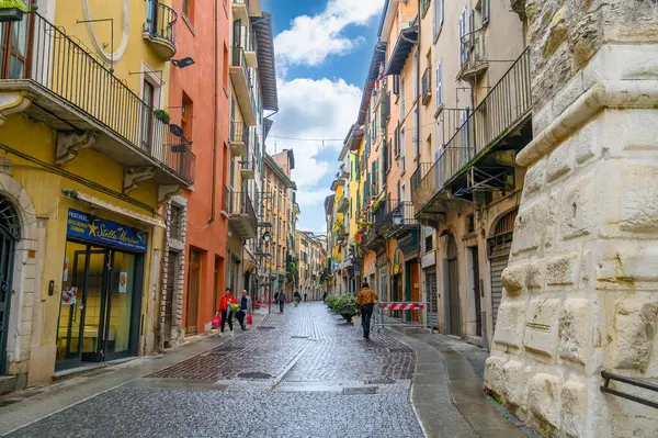 Brescia, İtalya. Geleneksel renkli bir bina, balkonları, pencereleri ve tipik İtalyan caddesinde çok renkli duvarları var.