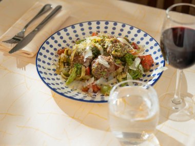 Peynirli sebzeli makarna ve kırmızı şarap eşleşmesi.