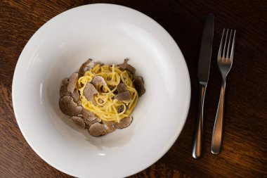 Beyaz kasede traşlı mantarlı gurme spagetti.