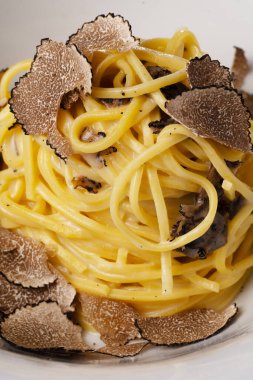 Beyaz kasede traşlı mantarlı gurme spagetti.