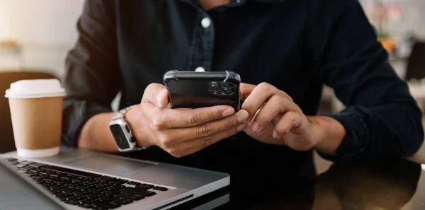 Erkek Eli Dizüstü Bilgisayarda Yazıyor Modern Ofiste Akıllı Telefon Tutuyor — Stok fotoğraf