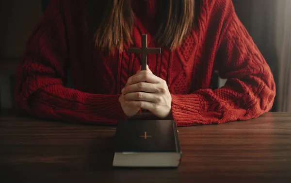partial view of religious woman Hands at table with cross and bible book