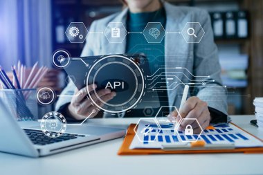 Dijital tablet kullanan, ofis masasında oturup kağıda notlar yazan bir iş kadını görüntüsü. api dijital sanal simgeleri 