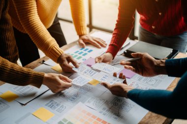 Ofis masasındaki yaratıcı dijital geliştirme ajansı. Web sitesi için UX grafik tasarımcıları uygulama planlıyorlar 