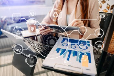 Dijital tablet kullanan ve ofis masasında oturan iş kadını görüntüsü. 