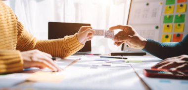 UX geliştiricileri ve tasarımcılar masada beyin fırtınası yapıyorlar. Web arayüzü tasarım projesi