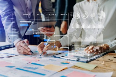  Proje yöneticisi çalışıyor ve görevleri güncelliyor ve sanal diyagram çizimi yapıyor. Akıllı telefon, tablet ve dizüstü bilgisayarla 