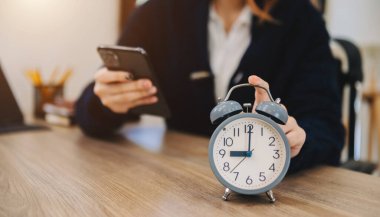Masadaki çalar saat. Ofis binasında çalışmak ya da gece evde dizüstü bilgisayarla çalışmak. ve akıllı telefon.