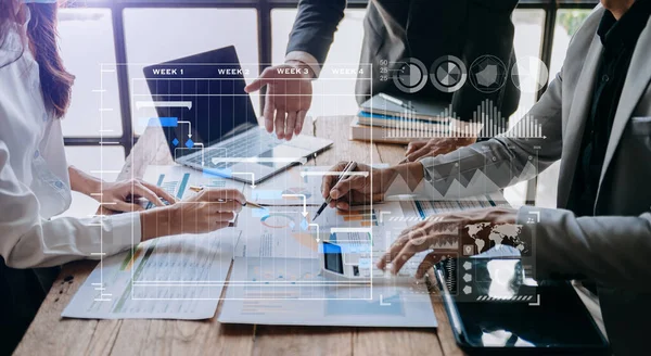 stock image Project managers working on update tasks and Gantt chart scheduling virtual diagram, laptop and papers on table  