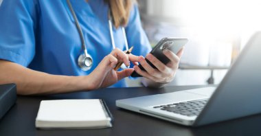Tıbbi teknoloji konsepti. Doktor cep telefonu ve steteskopla çalışıyor. 