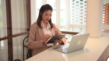 Bilgisayarlı ve dijital tablet kullanan Asyalı bir kadın. 