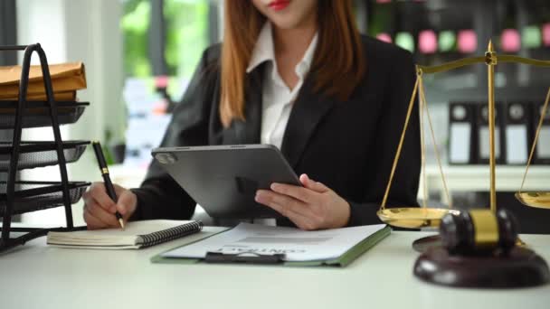 デジタルタブレットを使った事務所の机で弁護士の女性の部分的見解と紙のノートを作る — ストック動画