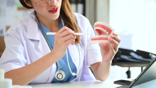 Οδοντίατρος Γυναίκα Στο Τραπέζι Κρατώντας Δείγμα Γνάθου Μοντέλο Δοντιών Και — Αρχείο Βίντεο