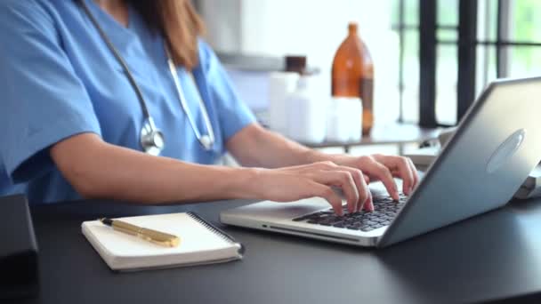 女医生 带听诊器 在办公桌前工作 使用笔记本电脑 — 图库视频影像