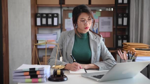 弁護士コンサルタントノートパソコンとノートブックの配線でテーブルで働くアジアの女性 — ストック動画