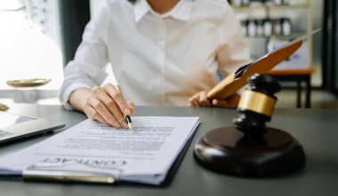 Masada çekiç var. Sözleşme belgeleriyle çalışan avukat kadın.  