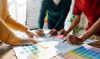 UX geliştiricileri ve ui tasarımcıları ofis masasındaki uygulama arayüzü tasarımında beyin fırtınası yapıyorlar 