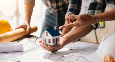 Mimarlarla dolu bir masayı yakından çek. İki mimar ofiste mimari model oluşturuyorlar. Yeni bir bina oluşturmak için.