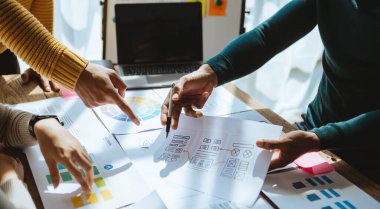 UI müteahhitlerinin projelerini dizüstü bilgisayar, akıllı telefon ve dijital tablet ile beyin fırtınası yaparken görüntülerini kapatın. Yaratıcı dijital geliştirme ajansı