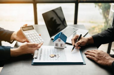 Emlak komisyoncusu, emlak kredisi teklifiyle ilgili sözleşme imzalama anlaşmasını, ev modelini sunar ve müşteriye danışmanlık yapar.