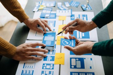 UI müteahhitlerinin projelerini dizüstü bilgisayar, akıllı telefon ve dijital tablet ile beyin fırtınası yaparken görüntülerini kapatın. Yaratıcı dijital geliştirme ajansı