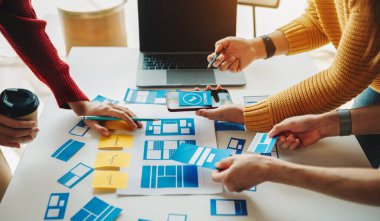 UI müteahhitlerinin projelerini dizüstü bilgisayar, akıllı telefon ve dijital tablet ile beyin fırtınası yaparken görüntülerini kapatın. Yaratıcı dijital geliştirme ajansı