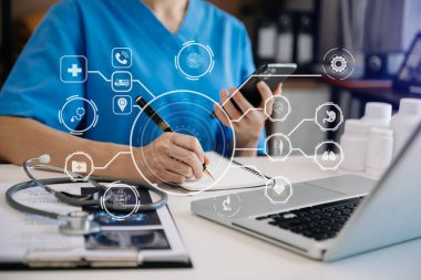 Doctor works with mobile devices on the Internet in the office. on hologram, modern virtual icons