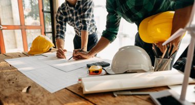 Engineer Teamwork Meeting, Drawing working on blueprint meeting for project working with partner on model building at company office. 