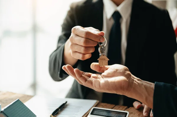 Buying a home or insurance deal, an insurance agent pointing a pen to those interested in renting a house, a contract, signing an Home buying agreement