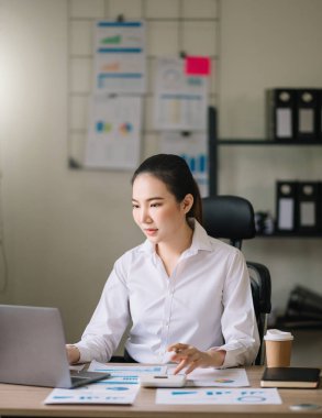 Young beautiful woman using laptop and tablet while sitting at her working place. Concentrated at work. at office