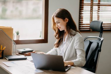 Businesswoman working in the office with working notepad, tablet and laptop documents