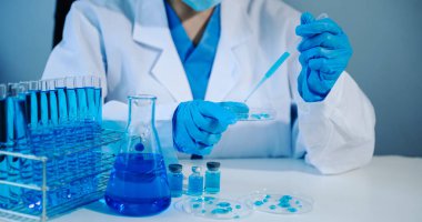 Asian young  student scientist researching and new chemical substances in a laboratory. blue effect