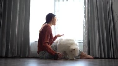 woman in Depression sits with cat by window 