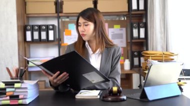 Beautiful Asian businesswoman typing on tablet at the table at the office