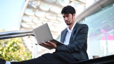 Businessman working at office with laptop, outside 
