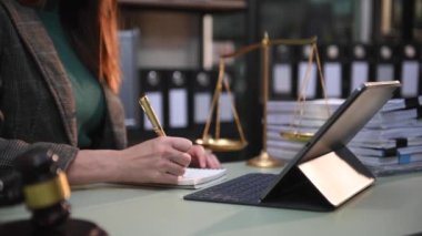 justice and law concept. woman judge in a courtroom the gavel, working with  digital tablet computer on wood table