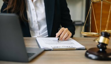 justice and law concept. woman lawyer working and judge in a courtroom the gavel, working with tablet and laptop and digital tablet computer on white table