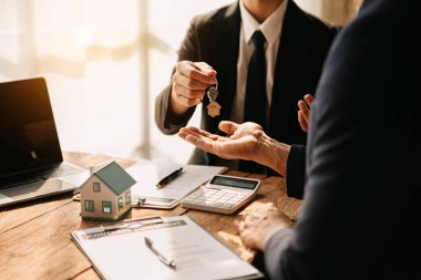 Buying a home or insurance deal, an insurance agent pointing a pen to those interested in renting a house, a contract, signing and Home buying agreement
