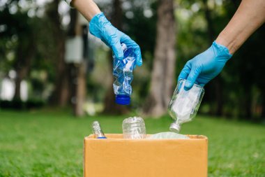 hands holding garbage bottle plastic and glass putting into recycle bag .pollution, ecology and plastic concept